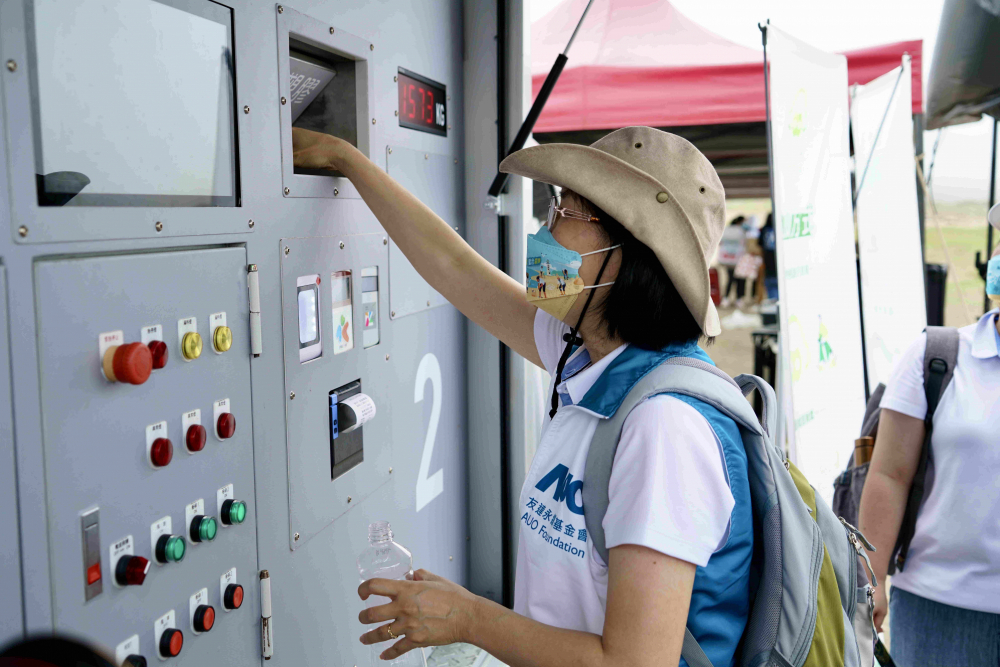 志工們將拾起的寶特瓶投入「好歸塑專車」，讓廢棄塑料空瓶可以直接粉碎、縮小體積，未來將可再製成購物袋、寶特衣、悠遊卡等生活用品